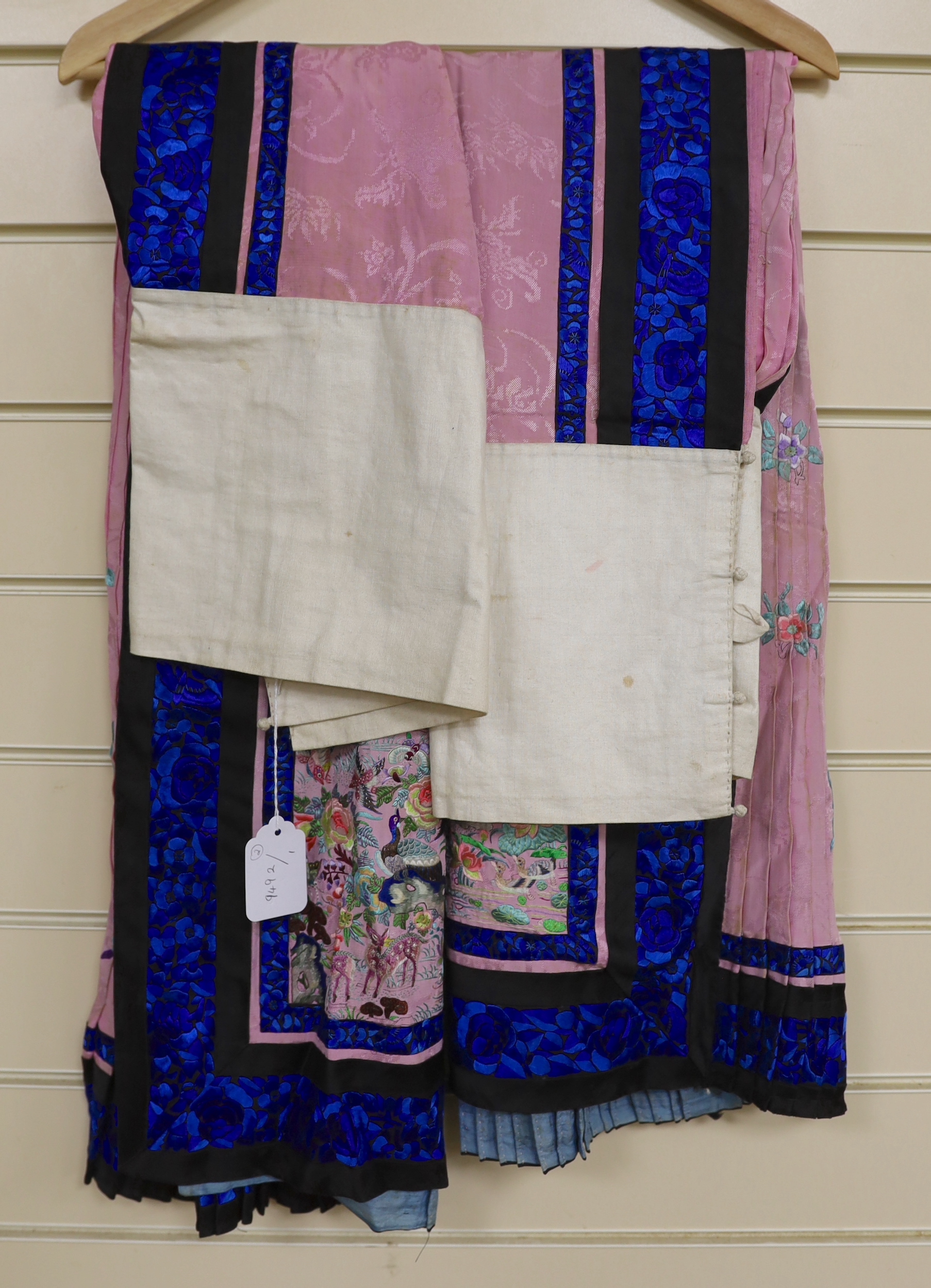 Two Chinese late 19th century lilac silk damask skirts, with polychrome silk front panels embroidered with birds, animals and pagoda, with blue embroidered border panels on black silk.